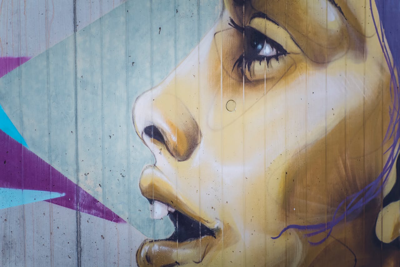 Close-up of colorful street art depicting a woman's face on a concrete wall.